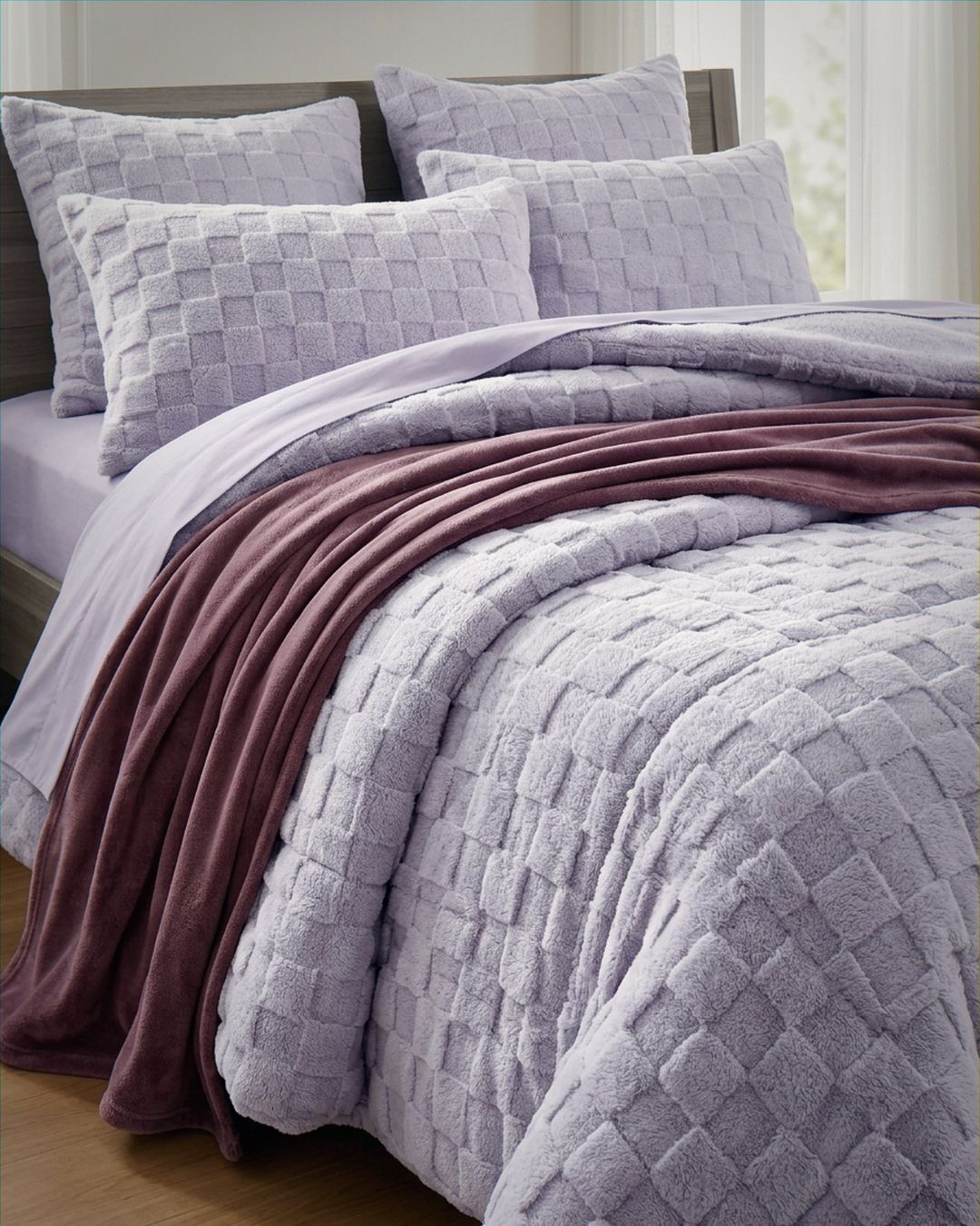 Lavender checkered snuggle fleece comforter set styled on bed with matching pillows and mauve throw blanket