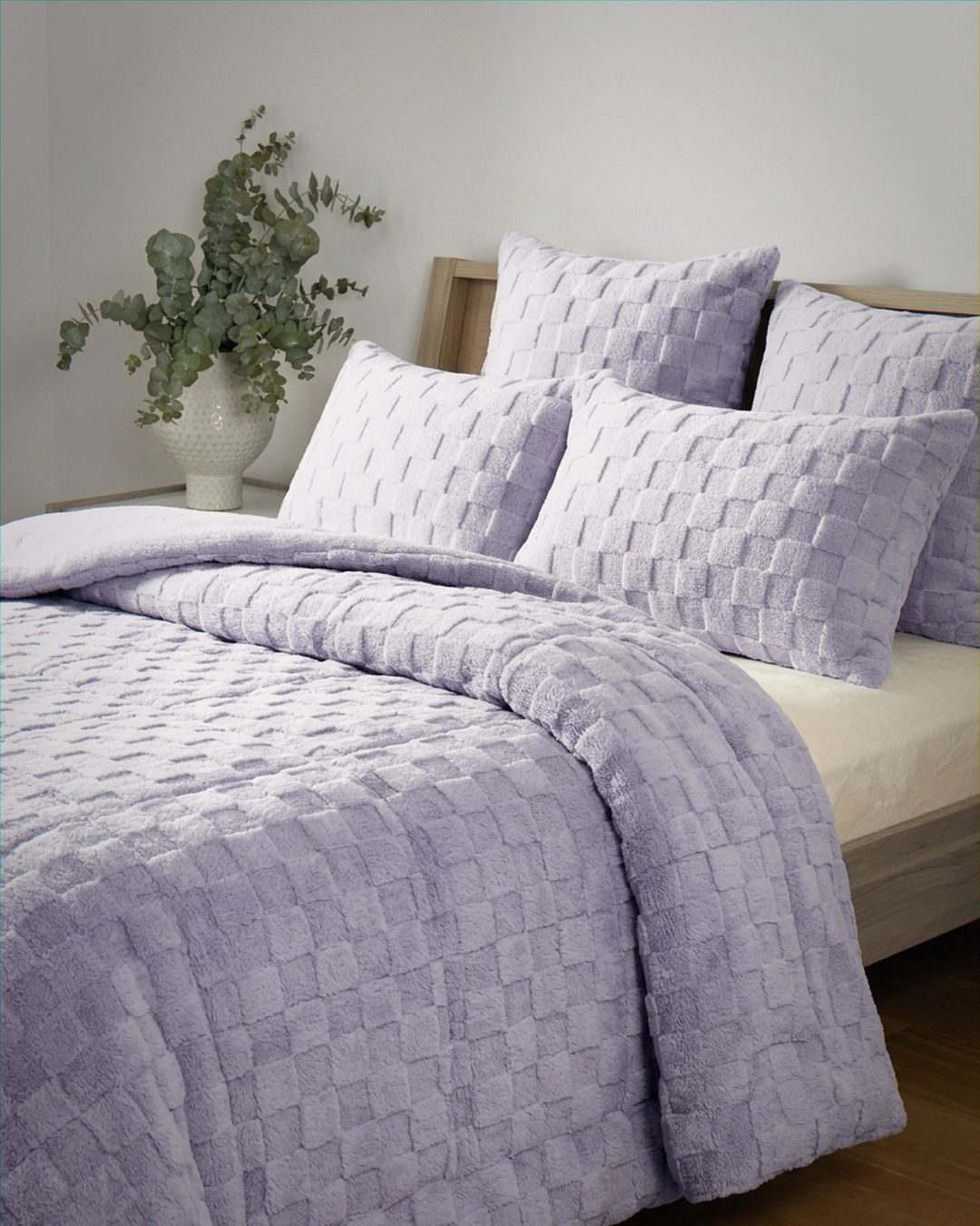Lavender checkered snuggle fleece comforter set styled on a bed with matching pillows and eucalyptus decor.