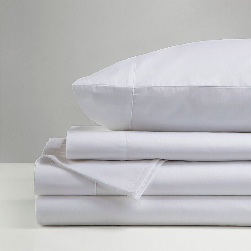 The Morgan and Reid Hotel 1500 Thread Count Cotton Rich Sheet Set, with pillowcases and one pillow on top, is neatly stacked and displayed against a plain light gray background.