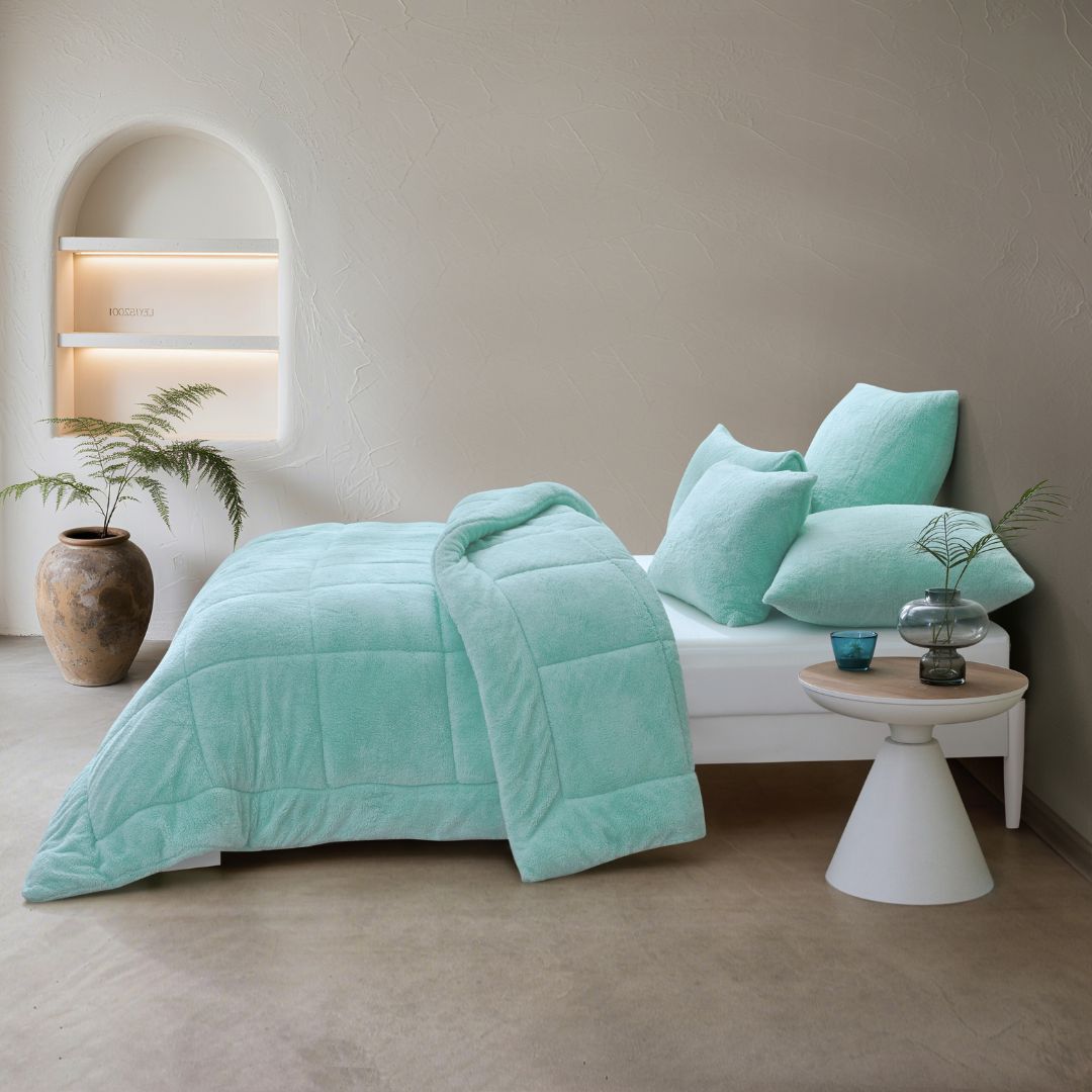 Turquoise bedding set on a bed in a modern bedroom with neutral decor.