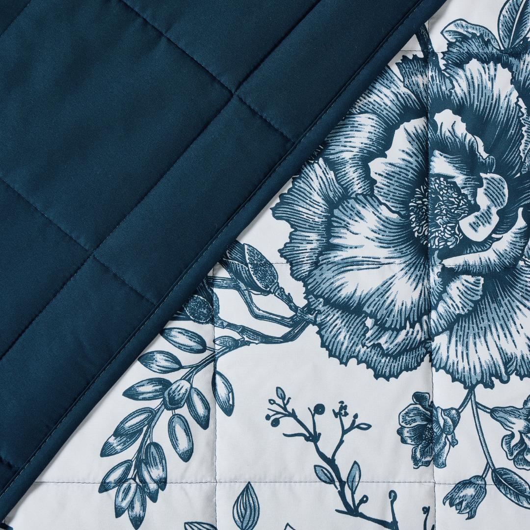 Lightweight quilted coverlet with pillowcases in classic blue rose design.