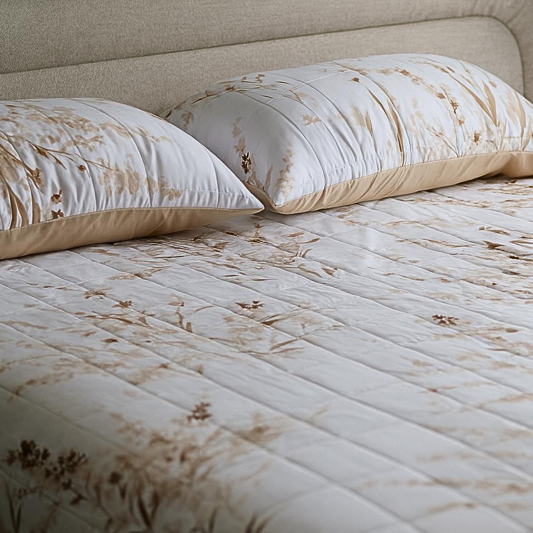 Close-up of golden floral quilted design and stitching.