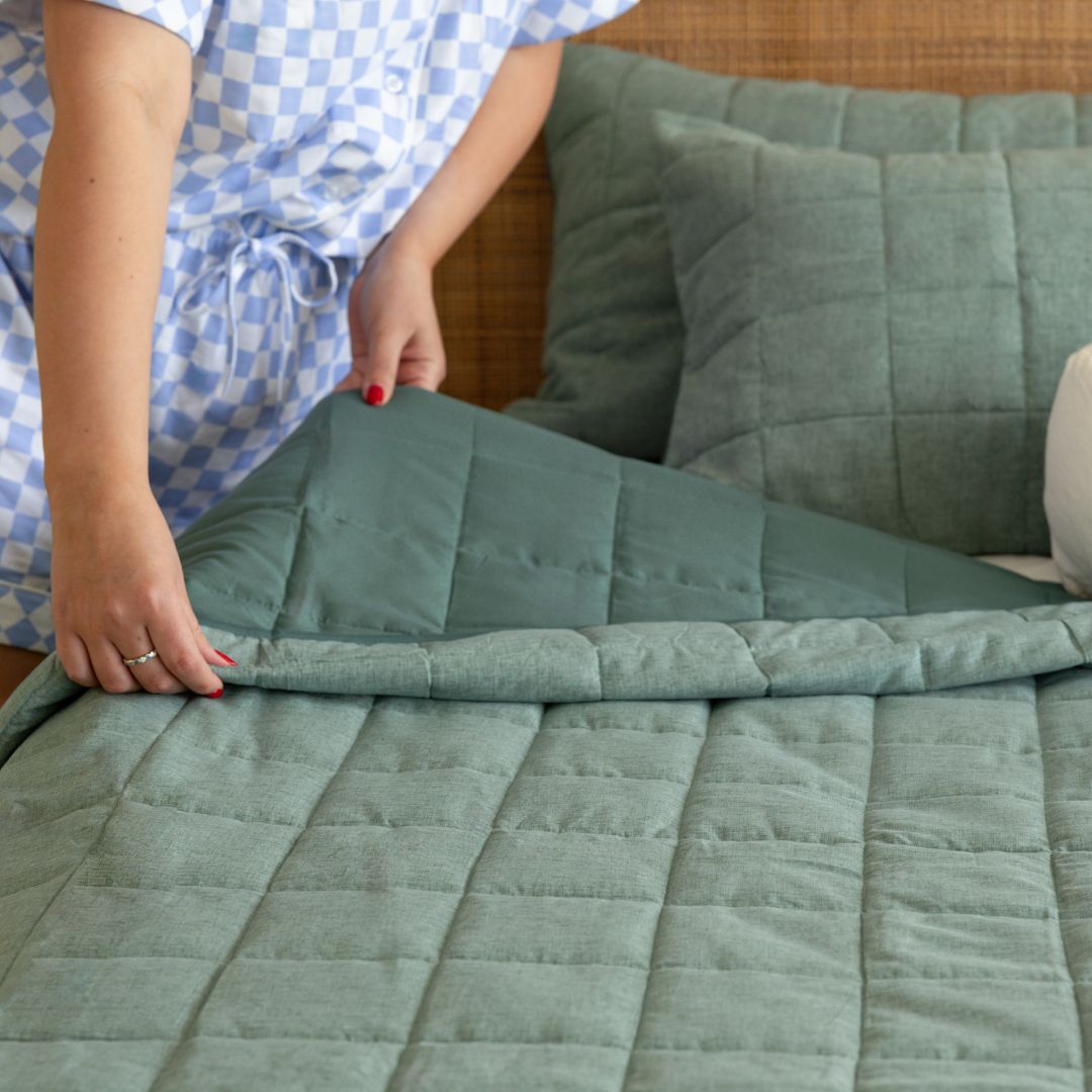 lady hands folding green quilt