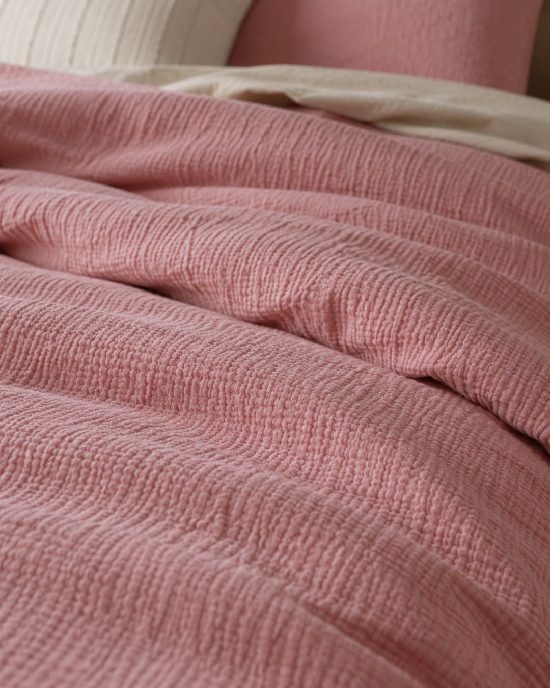Close-up of a textured pink fabric with a blurred background