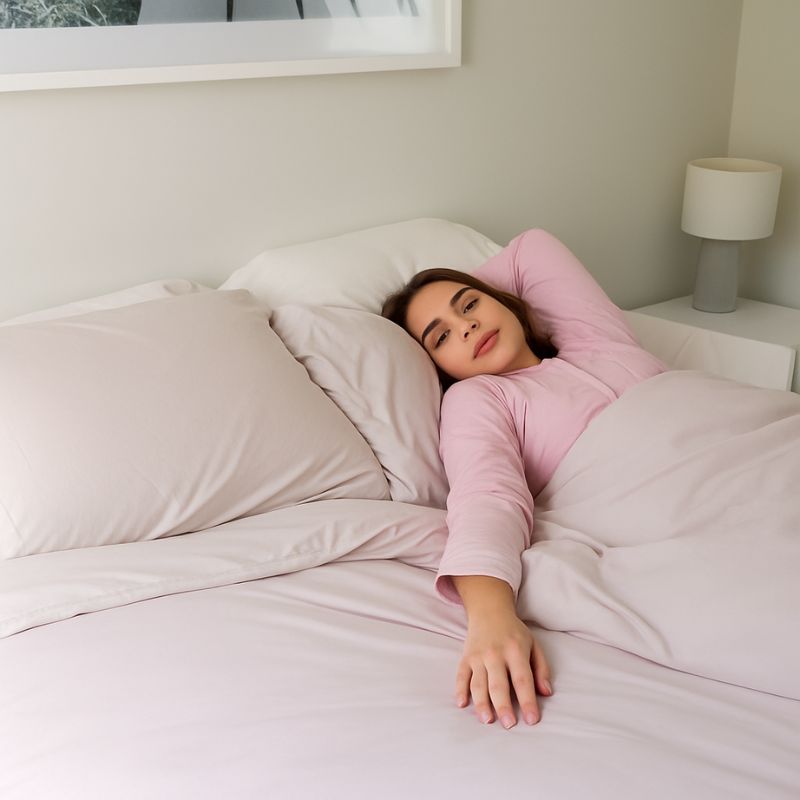 Morgan and Reid Perfect Pale Bamboo Ultra Cooling Comforter Set - Woman in pink pajamas lying in bed with white bedding
