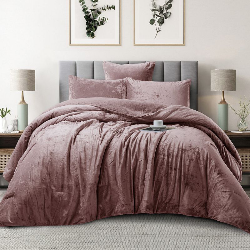 Pink textured comforter set on a bed in a bedroom with lamps and framed pictures.