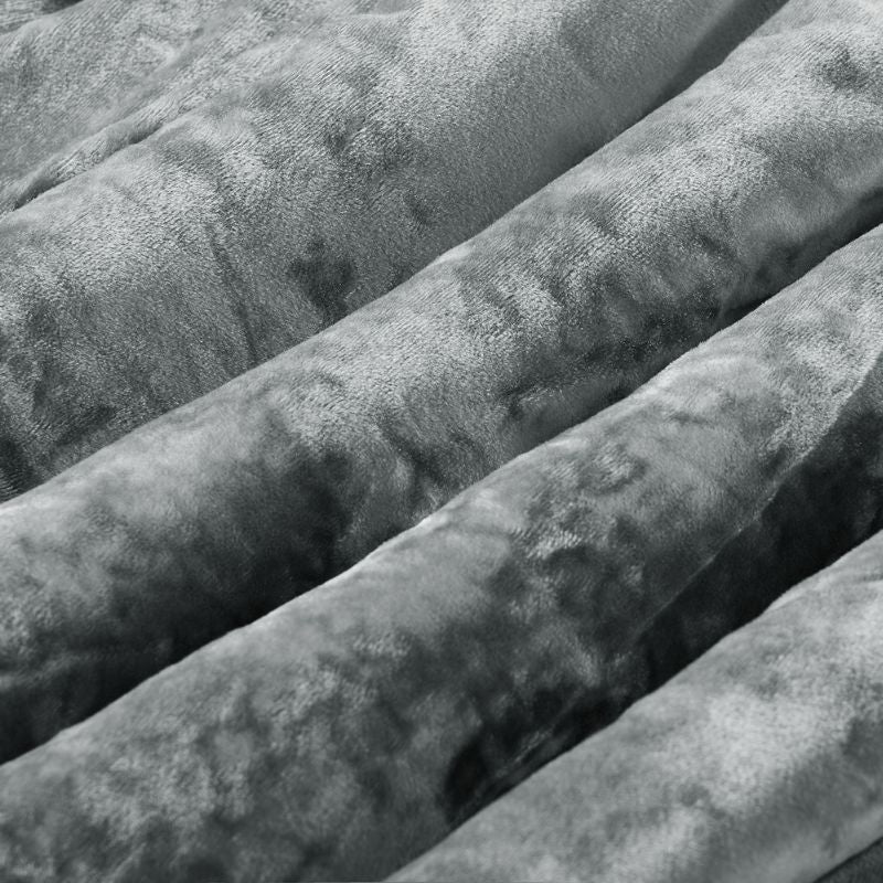 A neatly made bed features the Morgan and Reid Silver Velvet Crushed Snuggle Fleece Comforter Set with matching pillows,...