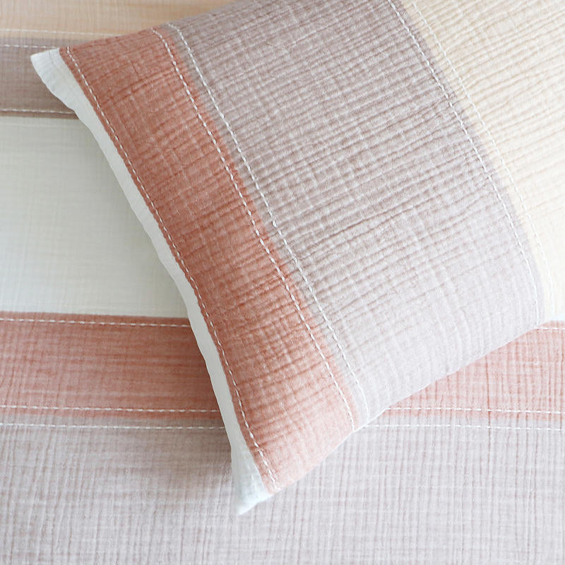 Styled bed featuring Renee Taylor Bayley European Pillowcases in soft earthy tones.