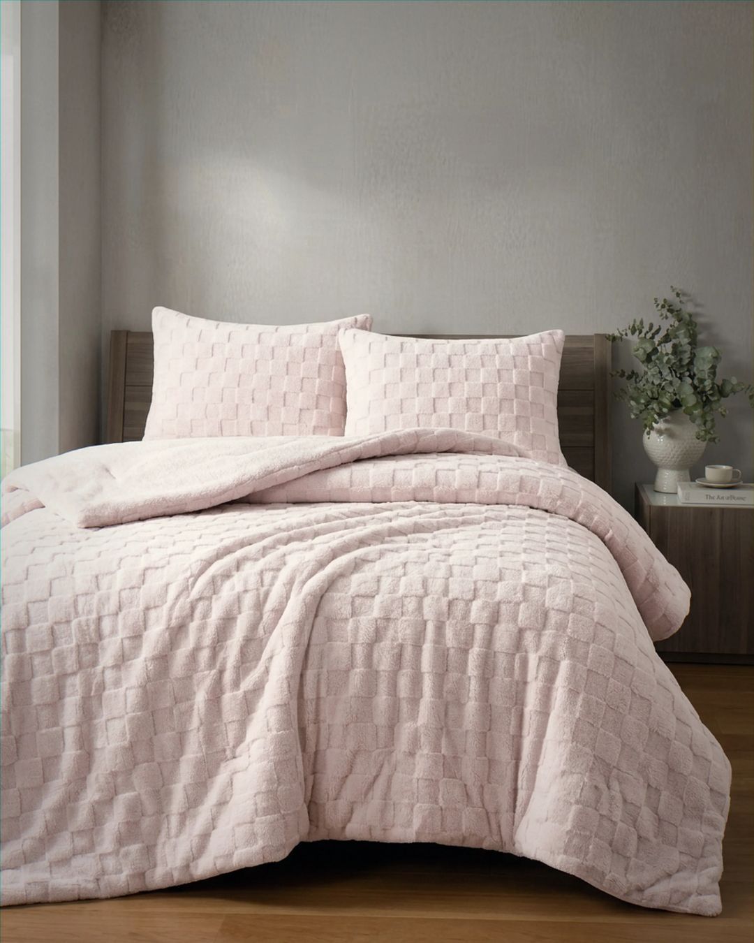 Soft pink checkered snuggle fleece comforter set styled on bed with matching pillow shams in cozy bedroom setting
