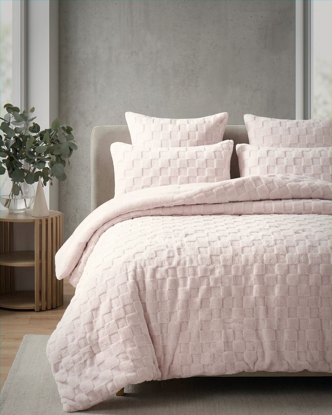 Soft pink checkered snuggle fleece comforter set styled on bed with matching pillows in modern bedroom