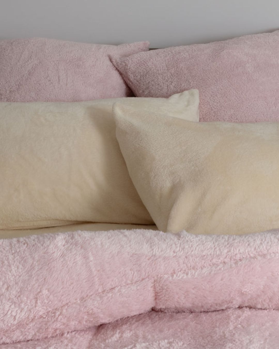 Morgan and Reid Chalk Pink Snuggle Fleece European Pillowcase Pair on bed with coordinating bedding