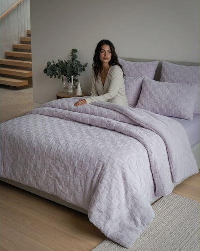 Lavender checkered snuggle fleece comforter set styled on a modern bed with matching pillowcases, lifestyle bedroom shot.