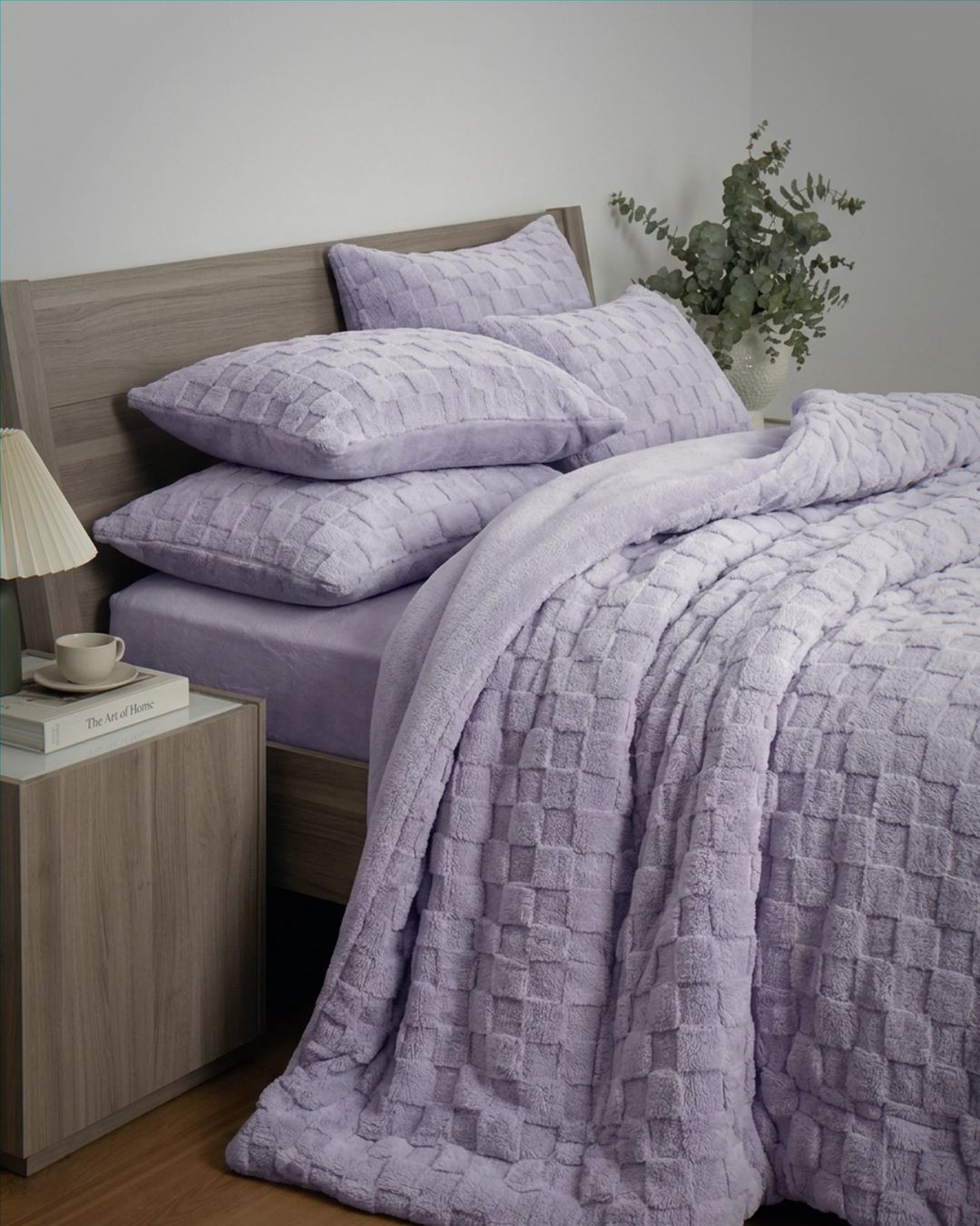 Lavender checkered snuggle fleece comforter set styled on bed with matching pillows and eucalyptus decor.
