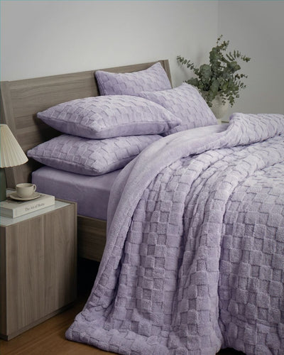 Lavender checkered snuggle fleece comforter set styled on bed with matching pillows and eucalyptus decor.