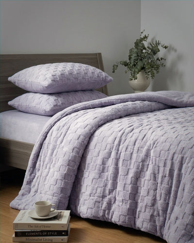 Lavender checkered snuggle fleece comforter set styled on bed with matching pillows and eucalyptus decor