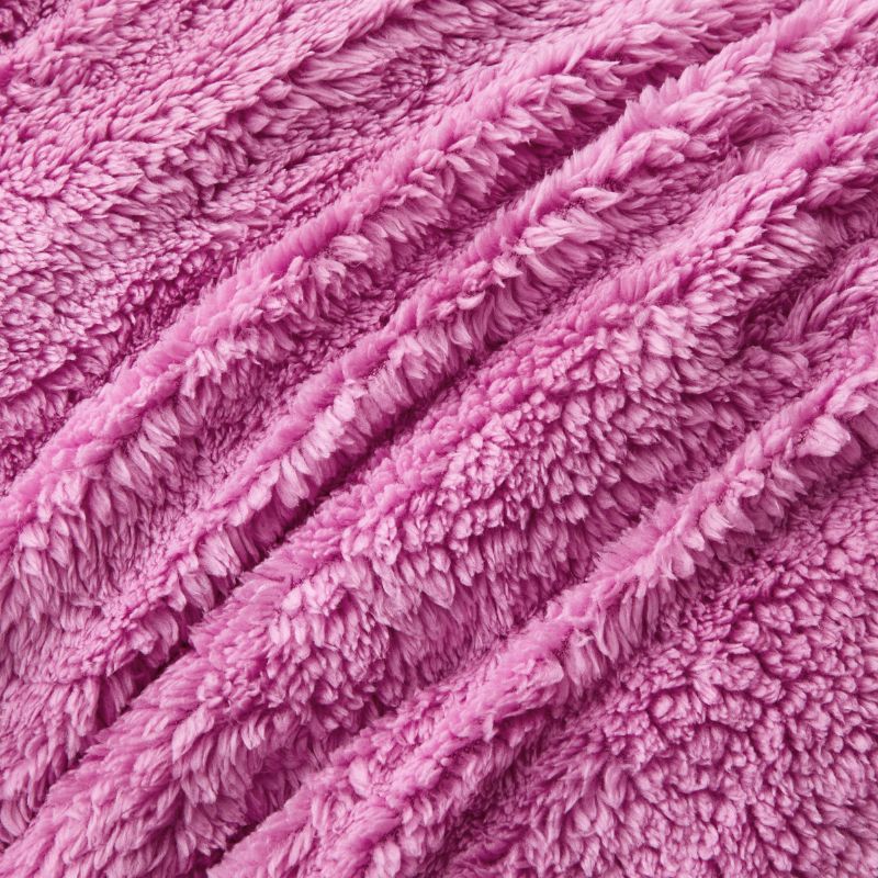 A vibrant crocus pink Snuggle Fleece Comforter set with layered pillows, adding warmth and colour to a modern bedroom.