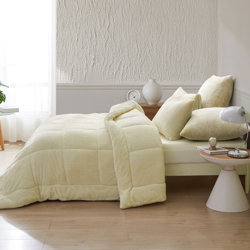 An ivory Snuggle Fleece Comforter set styled in a bright bedroom with a soft rug and timber accents for a calm, welcoming feel.