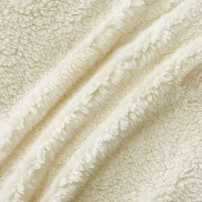 An ivory Snuggle Fleece Comforter set styled in a bright bedroom with a soft rug and timber accents for a calm, welcoming feel.