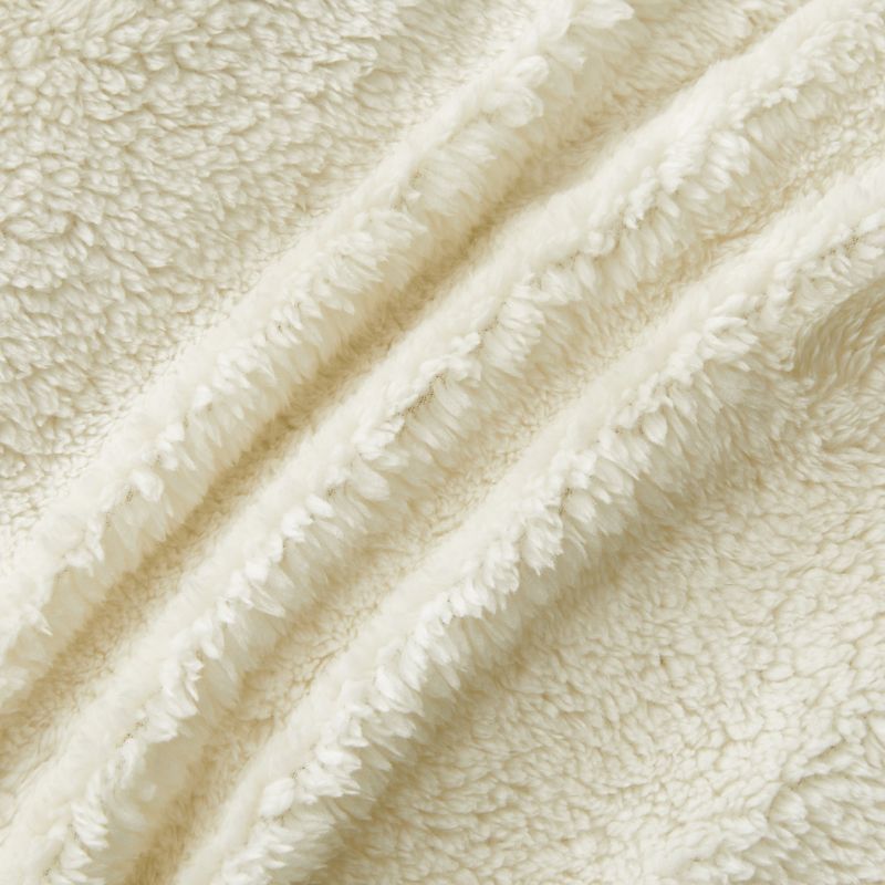 An ivory Snuggle Fleece Comforter set styled in a bright bedroom with a soft rug and timber accents for a calm, welcoming feel.