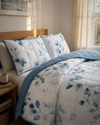 Floral bedding set on a bed in a bedroom with a side table and window.