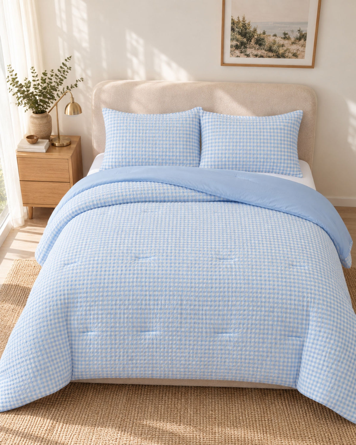A light blue and white gingham checkered bedding set, including a quilt and two matching pillowcases, styled on a bed in a bright, modern bedroom.