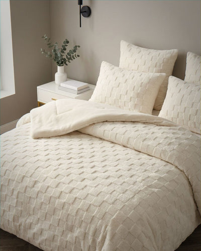 Morgan and Reid Checkered Cream Snuggle Fleece Comforter Set on a bed with matching pillowcases