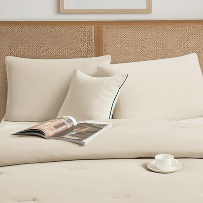 Lightweight coconut cooling comforter layered on rattan bed frame.