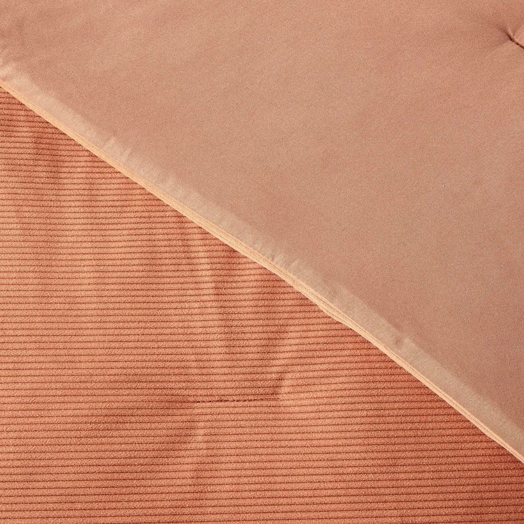 Close-up of a textured pink fabric with a ribbed pattern