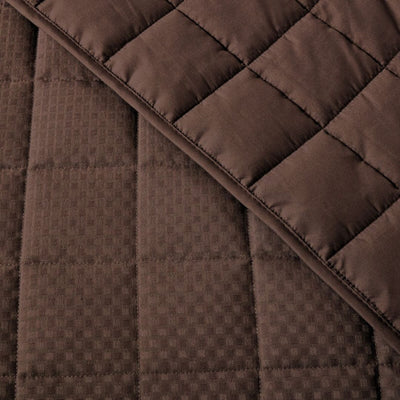 Close-up of a brown quilted fabric with a diamond pattern