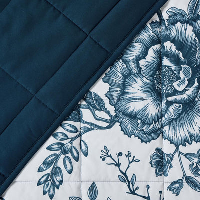 Lightweight quilted coverlet with pillowcases in classic blue rose design.