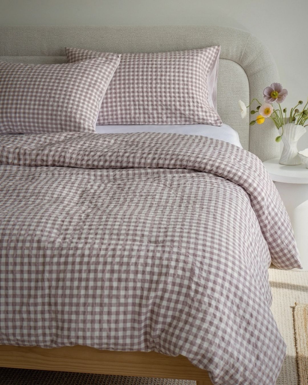 Bed with checkered bedding and pillows in a bedroom setting.