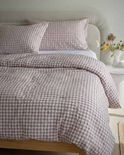 Bed with checkered bedding and pillows in a bedroom setting.