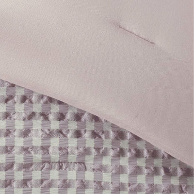 Close-up of a quilt with a checkered pattern on a plain background