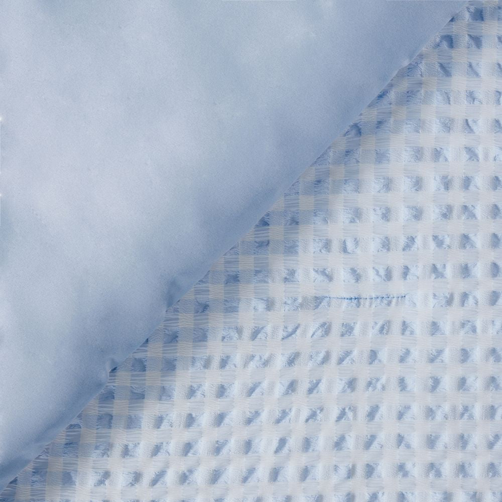 Close-up of blue and white checkered fabric with a textured pattern.