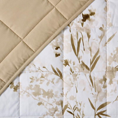 Close-up of golden floral quilted design and stitching.