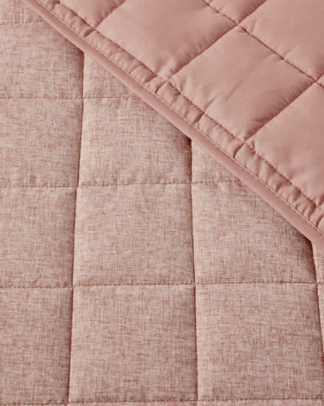 Close-up of a pink quilted fabric with a textured pattern
