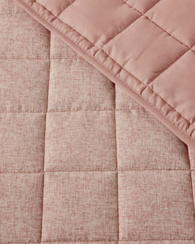 Close-up of a pink quilted fabric with a textured pattern