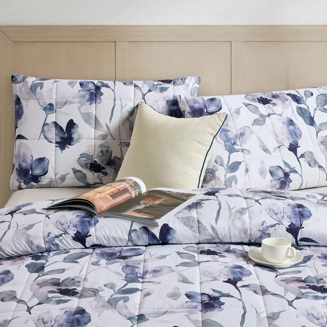 Morgan and Reid Midnight Orchid Cloudy Coverlet Set - Close-up of watercolour floral quilted fabric in grey and indigo.