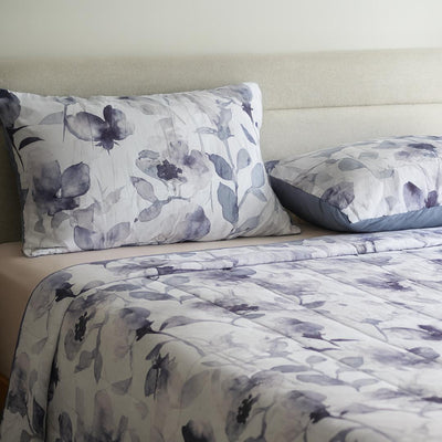 Morgan and Reid Midnight Orchid Cloudy Coverlet Set - Close-up of watercolour floral quilted fabric in grey and indigo.