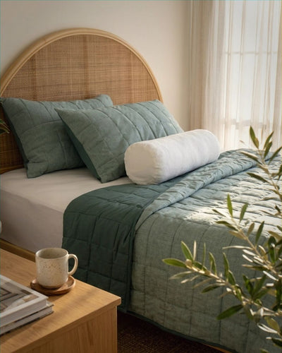 Bed with green bedding and a wooden headboard in a bedroom setting.