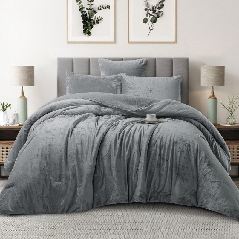 Gray textured comforter set on a bed in a bedroom with lamps and wall art.