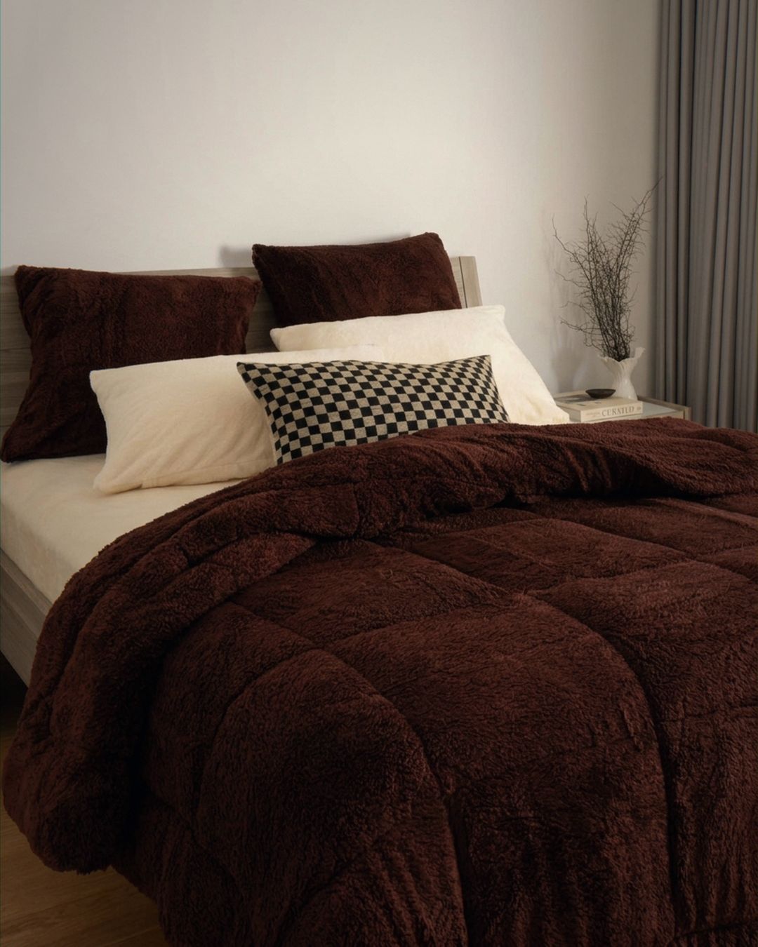 Bed with brown comforter and pillows in a bedroom setting