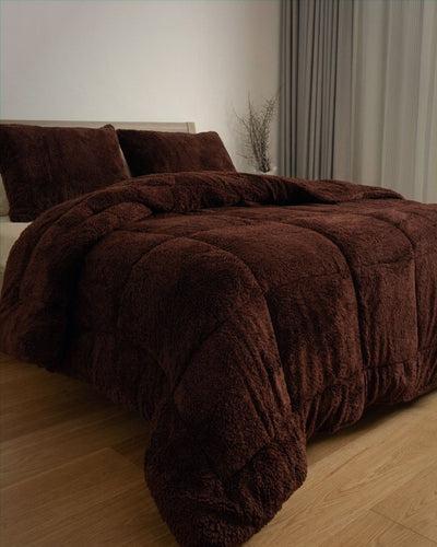 Brown plush comforter on a bed in a bedroom setting