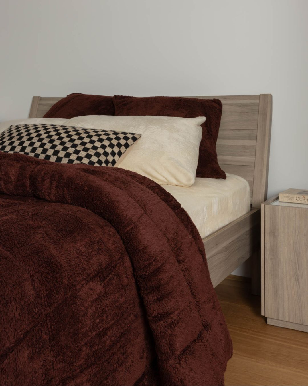 Bed with brown comforter and pillows in a bedroom setting
