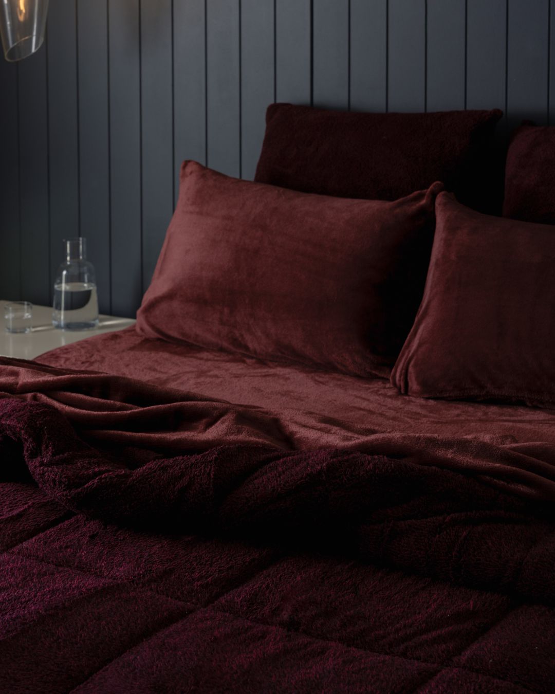 Detail shot of the Morgan and Reid Burgundy Black Snuggle Fleece Pillowcase Pair on pillows