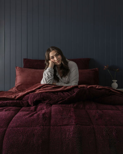 Morgan and Reid Burgundy Black Snuggle Fleece Comforter Set on a bed with matching pillowcases