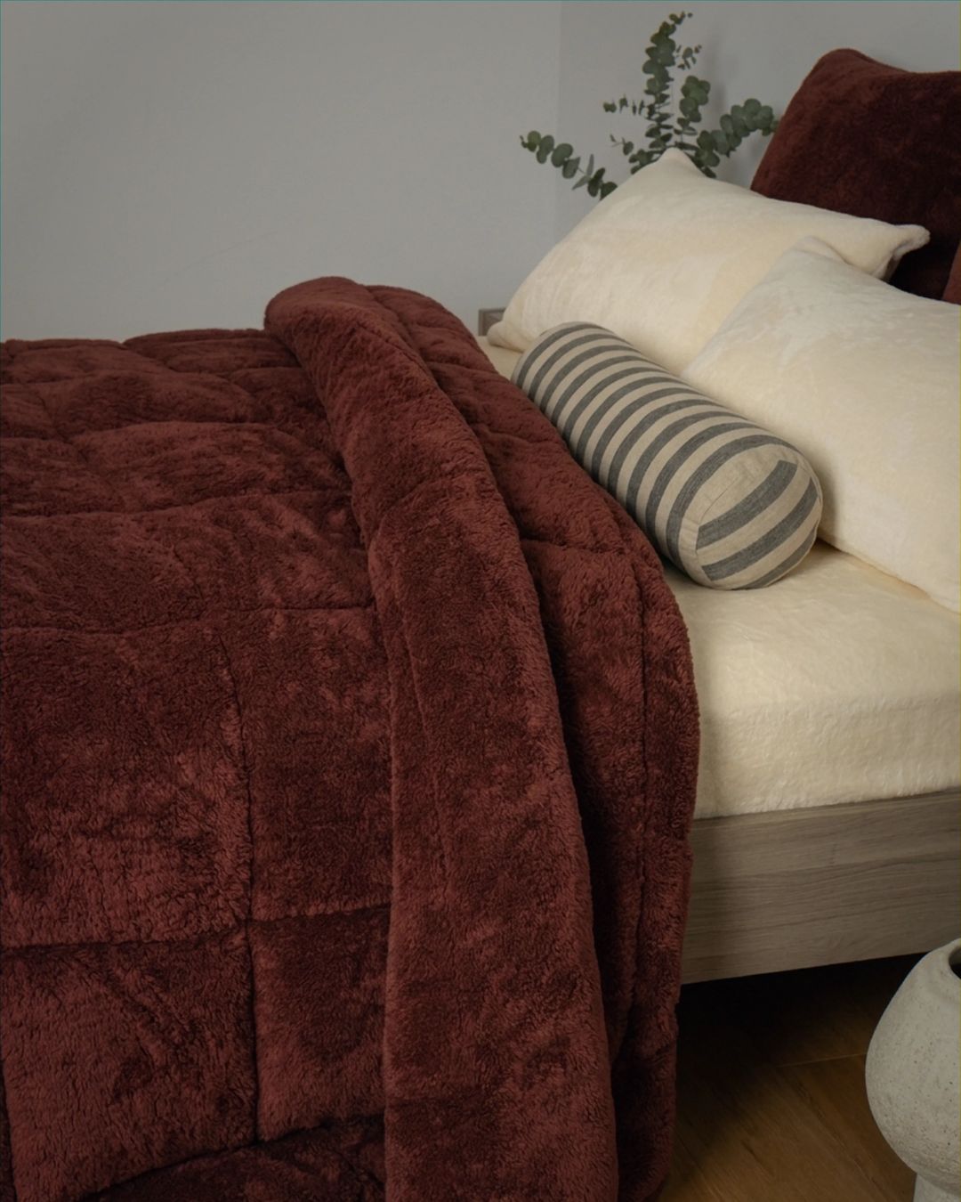 Brown textured blanket draped over a white sofa with decorative pillows.