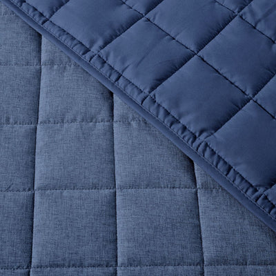 Close-up of a blue quilted fabric with a diamond pattern