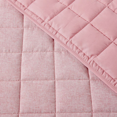 Close-up of a pink quilted fabric with a diamond pattern