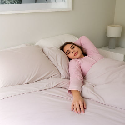 Morgan and Reid Perfect Pale Bamboo Ultra Cooling Comforter Set - Woman in pink pajamas lying in bed with white bedding